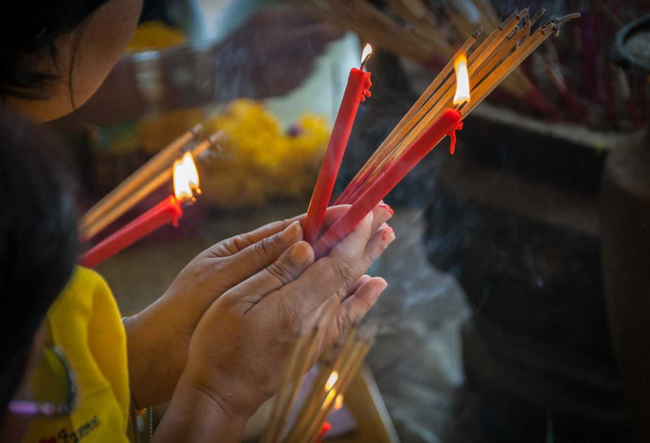 Woman's hands in prayer at the Buddhist shrine in Bangkok