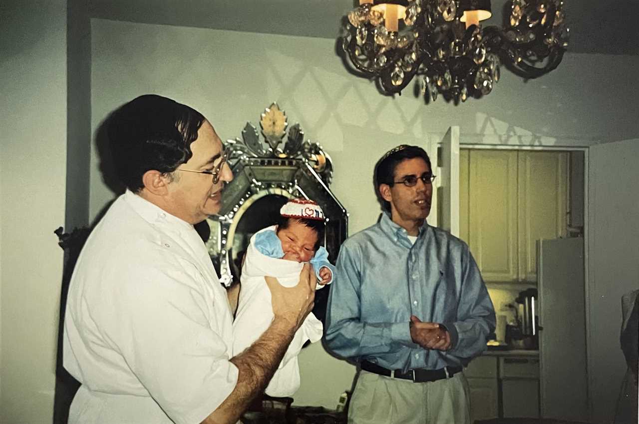 Alec, precisely eight days out of the womb, getting circumcised by the rabbi at his bris.