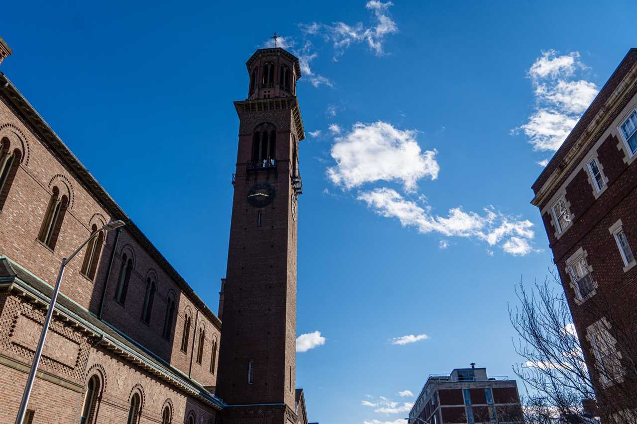 The clock tower at St. Paul's Catholic Church forms a stark silhouette against the winter sky.