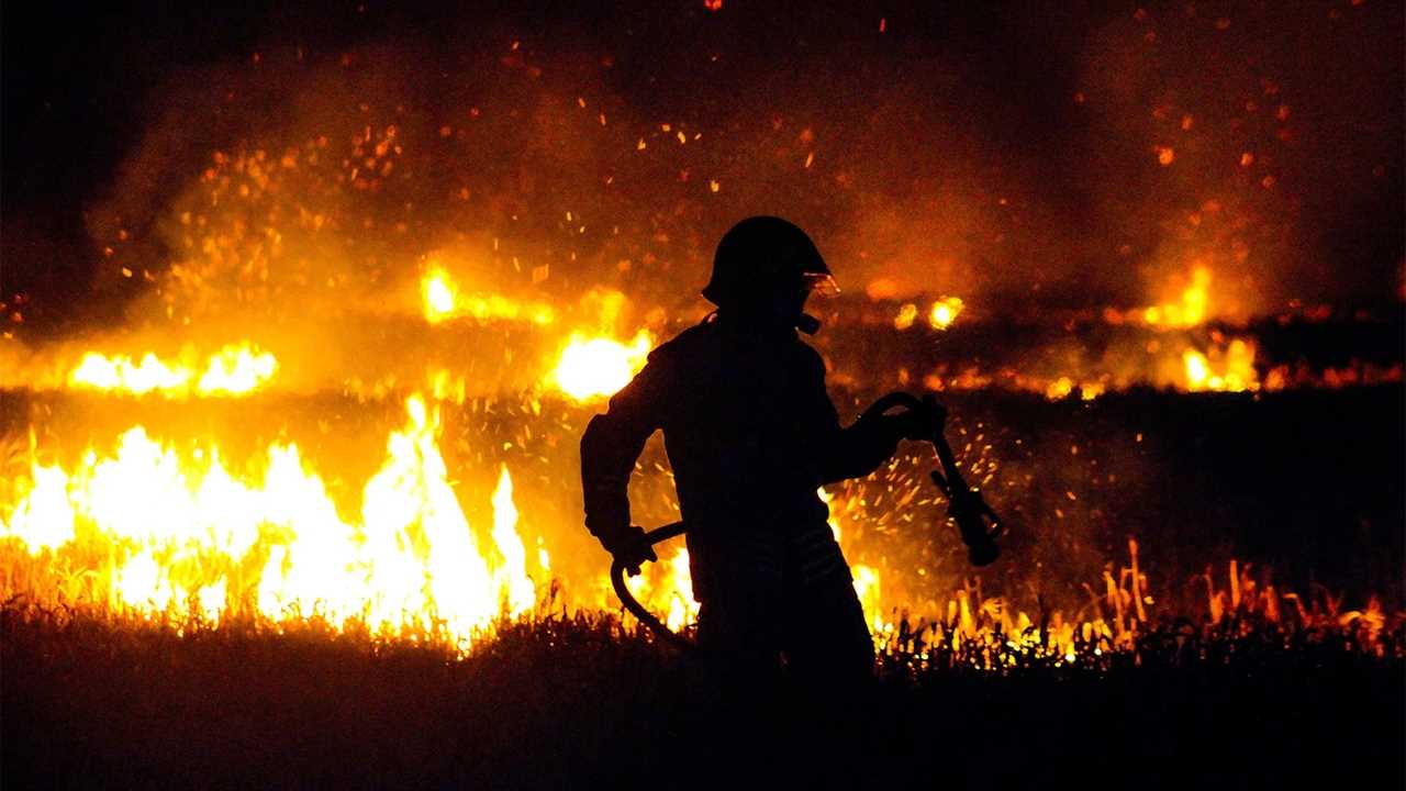 A firefighter pulls a hose to use on a bush fire.  Photo by Fabian Jones/Unsplash/Creative Commons