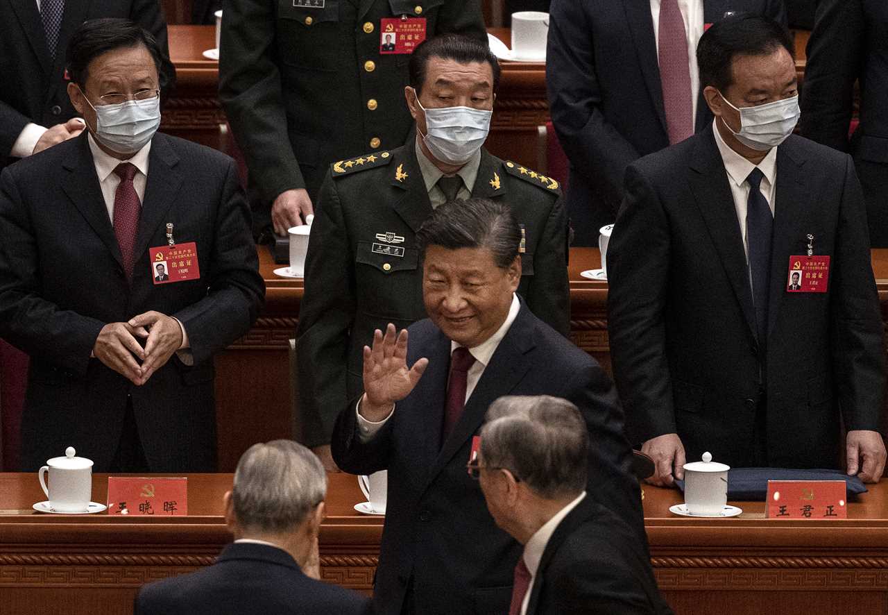 Chinese President Xi Jinping (center) waves to senior members of the government as he leaves at the end of the opening ceremony of the 20th National Congress of the Communist Party of China at The Great Hall of People in Beijing on Sunday.